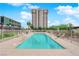 Outdoor pool with lounge chairs and desert landscaping, in front of high rise building at 3930 University Center Dr # 202, Las Vegas, NV 89119