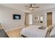 Bright main bedroom with a ceiling fan, wood floors, a TV, and ample natural light at 4135 Pistachio Nut Ave, Las Vegas, NV 89115