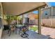Cozy covered patio with outdoor dining set, brick pavers, and a view of the fenced backyard at 4135 Pistachio Nut Ave, Las Vegas, NV 89115