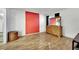 Living room featuring painted brick wall, wood flooring, dresser, and natural lighting at 4237 Brockton Green Ct, Las Vegas, NV 89110
