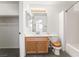 Bathroom with wood vanity, shower over tub, white tile and a large mirror at 5025 Starfinder Ave, Las Vegas, NV 89108
