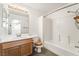 Bathroom with wood vanity, shower over tub, white tile and a large mirror at 5025 Starfinder Ave, Las Vegas, NV 89108