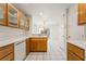Open kitchen with wooden cabinetry, white countertops, and tile flooring, leading to the living space at 5025 Starfinder Ave, Las Vegas, NV 89108