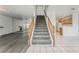 Spacious living area featuring staircase, tile flooring, laminate flooring, and kitchen access at 5025 Starfinder Ave, Las Vegas, NV 89108