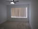 Bright bedroom features a ceiling fan, neutral carpet, and a window with blinds at 5241 Caspian Springs Dr # 103, Las Vegas, NV 89120