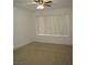 This bedroom features neutral carpet, a ceiling fan, and a window with vertical blinds at 5241 Caspian Springs Dr # 103, Las Vegas, NV 89120