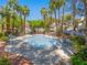 Inviting community pool surrounded by palm trees, seating, and lush landscaping at 5241 Caspian Springs Dr # 103, Las Vegas, NV 89120