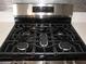 Close up on a black gas stovetop with a sleek stainless steel finish and modern design at 5241 Caspian Springs Dr # 103, Las Vegas, NV 89120