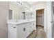 Bathroom with dual sinks, white cabinets, a large mirror and closet entrance at 5286 Monterey Park Cir, Las Vegas, NV 89146