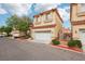 Street view of townhomes featuring desert landscaping, neutral stucco exteriors, and terracotta roofs at 5286 Monterey Park Cir, Las Vegas, NV 89146