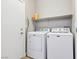 A practical laundry room featuring a washer, dryer, and convenient overhead shelving at 5286 Monterey Park Cir, Las Vegas, NV 89146