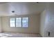 A well-lit bedroom featuring neutral walls, three large windows, and carpeted floors at 5445 Indian Cedar Dr, Las Vegas, NV 89135