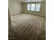 Spacious living room with neutral walls, carpet, and three windows for natural light at 5445 Indian Cedar Dr, Las Vegas, NV 89135