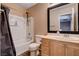 Bathroom with a shower-tub combo and a single vanity with wood cabinets at 5524 Overlook Valley St, North Las Vegas, NV 89081