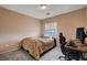 Cozy bedroom with neutral walls, carpet, and a window bringing in natural light at 5524 Overlook Valley St, North Las Vegas, NV 89081