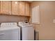 Bright laundry area featuring a modern washer and dryer, complemented by functional cabinetry for storage at 5524 Overlook Valley St, North Las Vegas, NV 89081