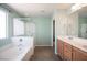 Bathroom featuring a separate tub and shower, double sinks, and light green walls at 5638 Jelsma Ave, Las Vegas, NV 89141