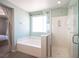 An elegant bathroom features a separate shower, a tub, and a large window that brightens the room at 5638 Jelsma Ave, Las Vegas, NV 89141