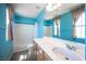 Bright bathroom featuring turquoise walls, a white shower-tub combo, and a long vanity at 5638 Jelsma Ave, Las Vegas, NV 89141