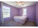 A cozy bedroom features large windows, lavender-colored walls, and carpeted floors at 5638 Jelsma Ave, Las Vegas, NV 89141