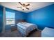 A bedroom features a ceiling fan, a window with curtains, and blue-painted walls at 5638 Jelsma Ave, Las Vegas, NV 89141