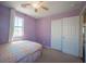 A purple bedroom with a window features a large closet and neutral carpet at 5638 Jelsma Ave, Las Vegas, NV 89141