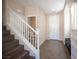 Inviting home entryway featuring tile flooring, staircase, and adjacent half bathroom and closet at 5638 Jelsma Ave, Las Vegas, NV 89141