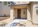 Covered front porch with a brown front door, desert landscaping, and exterior lighting at 5638 Jelsma Ave, Las Vegas, NV 89141