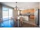 Kitchen with wood cabinets, stainless steel appliances, and sliding door to backyard at 5638 Jelsma Ave, Las Vegas, NV 89141