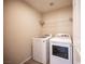 Bright laundry room with white washer, dryer, wire shelf and neutral paint at 5638 Jelsma Ave, Las Vegas, NV 89141