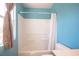 Shower-tub combo with white fixtures and a shower curtain in a blue-walled bathroom at 5638 Jelsma Ave, Las Vegas, NV 89141