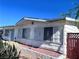 Cozy single-story home featuring white siding, window bars, and a tidy front yard with red rock landscaping at 6112 Denver Cir, Las Vegas, NV 89107