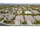 Aerial view of residential neighborhood showcases well-maintained homes and lush landscaping, with mature trees and city views at 616 Canyon Brook Pl, Las Vegas, NV 89145