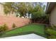 Private backyard featuring a putting green area, complemented by elegant landscaping, including mature trees and brick wall at 616 Canyon Brook Pl, Las Vegas, NV 89145