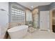 Modern bathroom features a glass enclosed shower, soaking tub, and marble style tile at 616 Canyon Brook Pl, Las Vegas, NV 89145