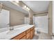 Bathroom featuring a large mirror, cherry wood cabinets, and a shower-tub combo at 637 Our Heritage St, Henderson, NV 89011