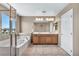 Bathroom featuring double vanity, large mirror, soaking tub, and a separate glass shower at 637 Our Heritage St, Henderson, NV 89011