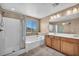 Bright bathroom featuring double sinks, soaking tub, glass shower and decorative lighting fixtures at 637 Our Heritage St, Henderson, NV 89011