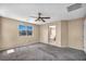 This carpeted bedroom offers natural light and a ceiling fan with an ensuite bathroom at 637 Our Heritage St, Henderson, NV 89011