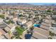 Overhead shot of a residential neighborhood, showcasing home with pool, landscaping, and nearby palm trees at 672 Peach Coral St, Las Vegas, NV 89183