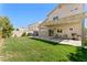 Spacious backyard with a covered patio, lush green lawn, and comfortable seating at 672 Peach Coral St, Las Vegas, NV 89183