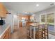 Bright kitchen with center island, tile floors, wood cabinets, and access to backyard at 672 Peach Coral St, Las Vegas, NV 89183
