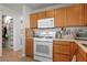 Kitchen features white appliances, wooden cabinets, and tile flooring at 672 Peach Coral St, Las Vegas, NV 89183
