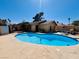 Backyard view of a refreshing in-ground pool with a tanning deck and patio furniture at 6786 Grandola Dr, Las Vegas, NV 89103
