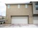 Two-car garage with a textured exterior and a brick driveway at 6824 Satin Silver Ct, North Las Vegas, NV 89086