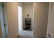 Clean hallway with neutral carpet and paint, shelving unit, and doorways leading to various rooms at 6824 Satin Silver Ct, North Las Vegas, NV 89086