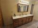 Bathroom featuring a double sink vanity, decorative mirror, and neutral color scheme at 7104 Carrondale Way, Las Vegas, NV 89128