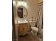 Bathroom with decorative sink vanity, oval mirror, toilet, and shower with curtain at 7104 Carrondale Way, Las Vegas, NV 89128
