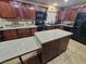 Beautiful kitchen boasting dark wood cabinets, a granite island, and stainless steel appliances at 7104 Carrondale Way, Las Vegas, NV 89128