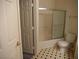 Bathroom featuring a tiled shower with a glass sliding door, toilet, and patterned flooring at 7147 S Durango Dr # 211, Las Vegas, NV 89113